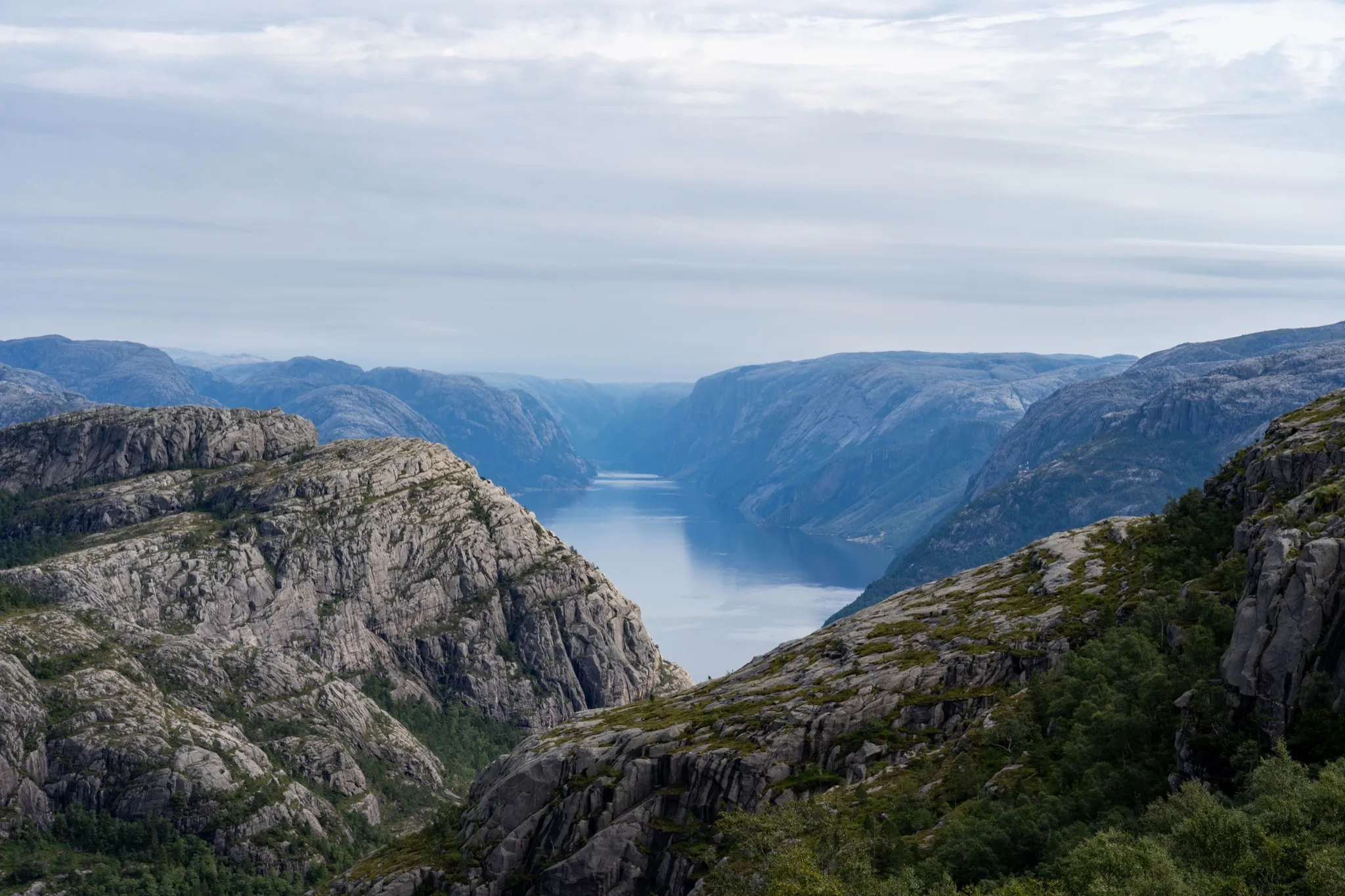 The Lysefjord winding between steep grey granite cliffs under an overcast sky in Norway